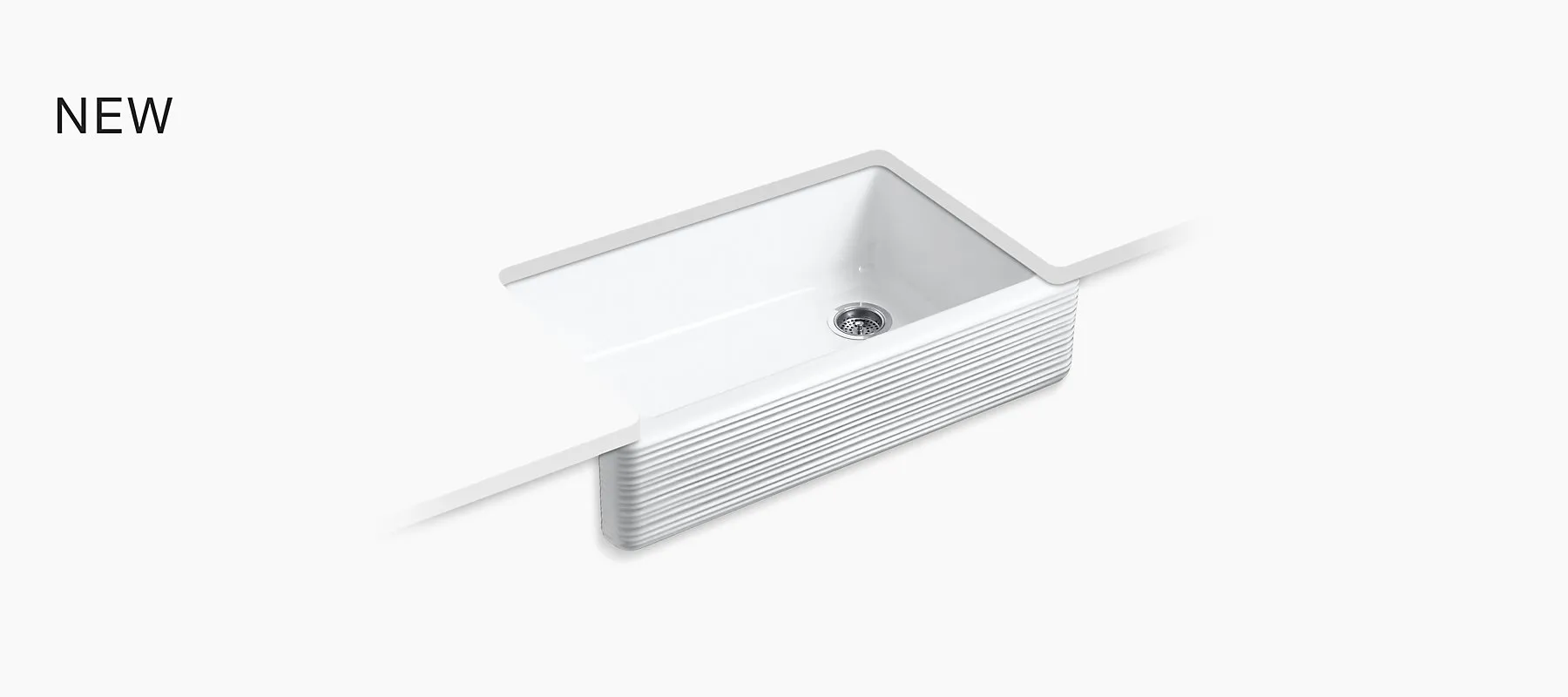 Kohler white cast-iron apron-front farmhouse sink with a fluted front panel