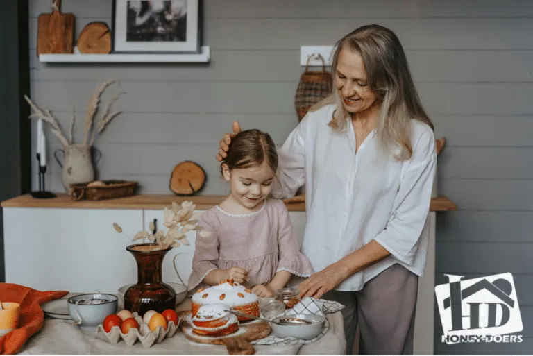 A grandmother and a young girl decorating a cake together at a kitchen island, with open shelving and cabinetry behind them