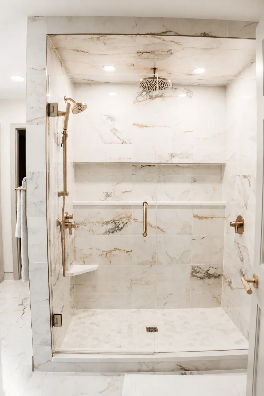 Pisa Gold tile shower with Champagne Bronze fixtures and glass enclosure in Burnsville bathroom remodel by Honey-Doers Remodeling