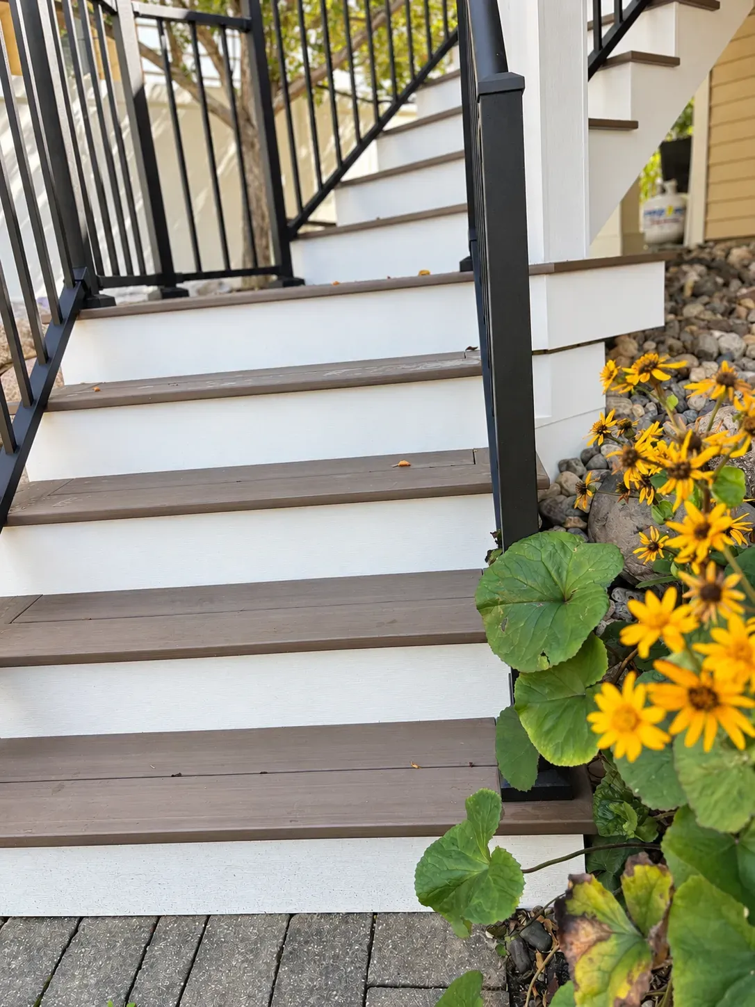 Composite stair treads with finished overhangs beside landscaping on the Eagan deck