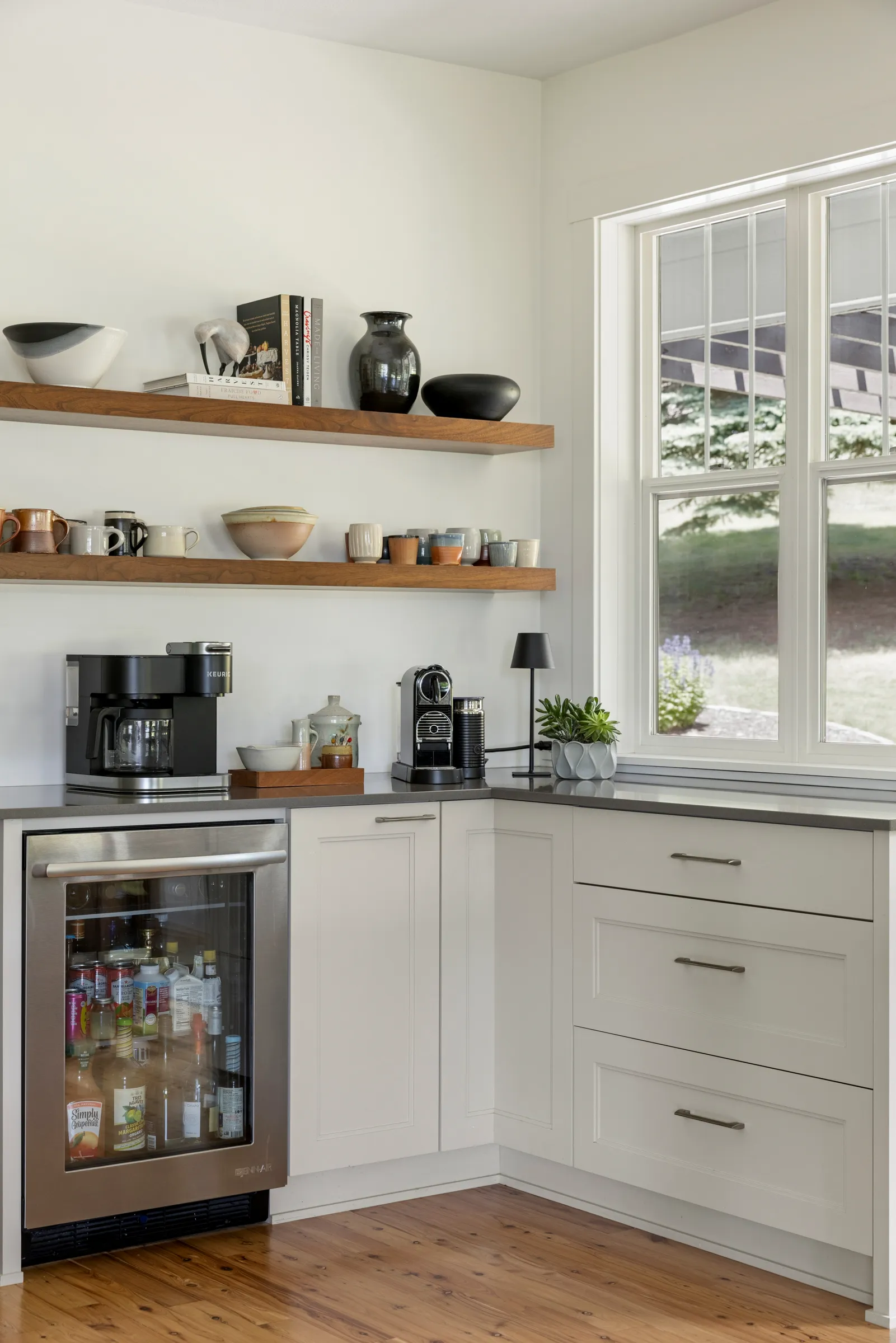 Black walnut floating shelves above a beverage station in a Lakeville kitchen remodel