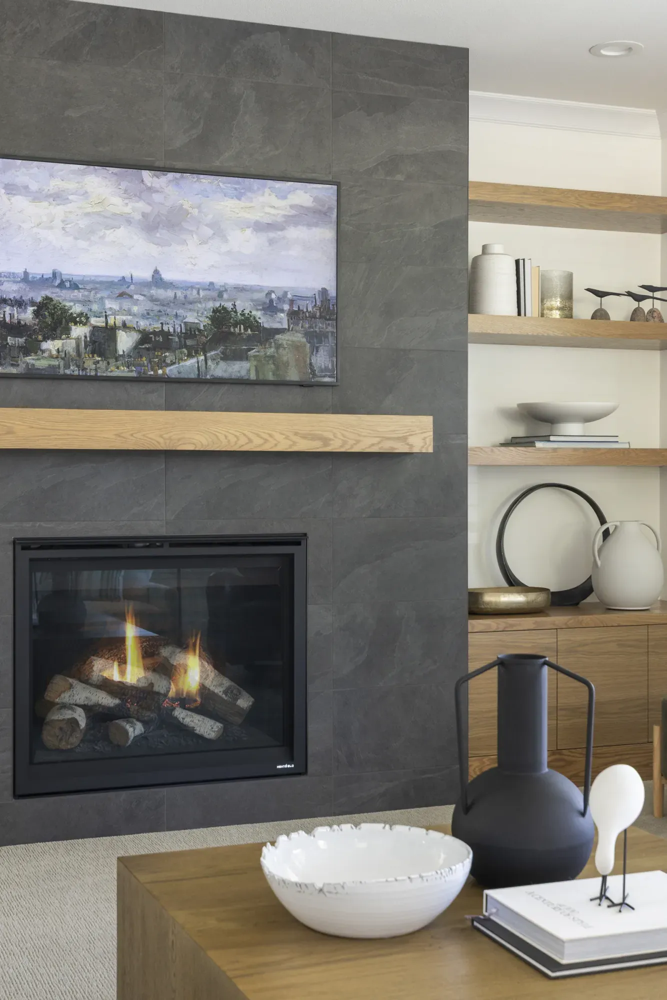Black porcelain tile fireplace wall with white oak mantel in a Lakeville, MN living room remodel by Honey-Doers