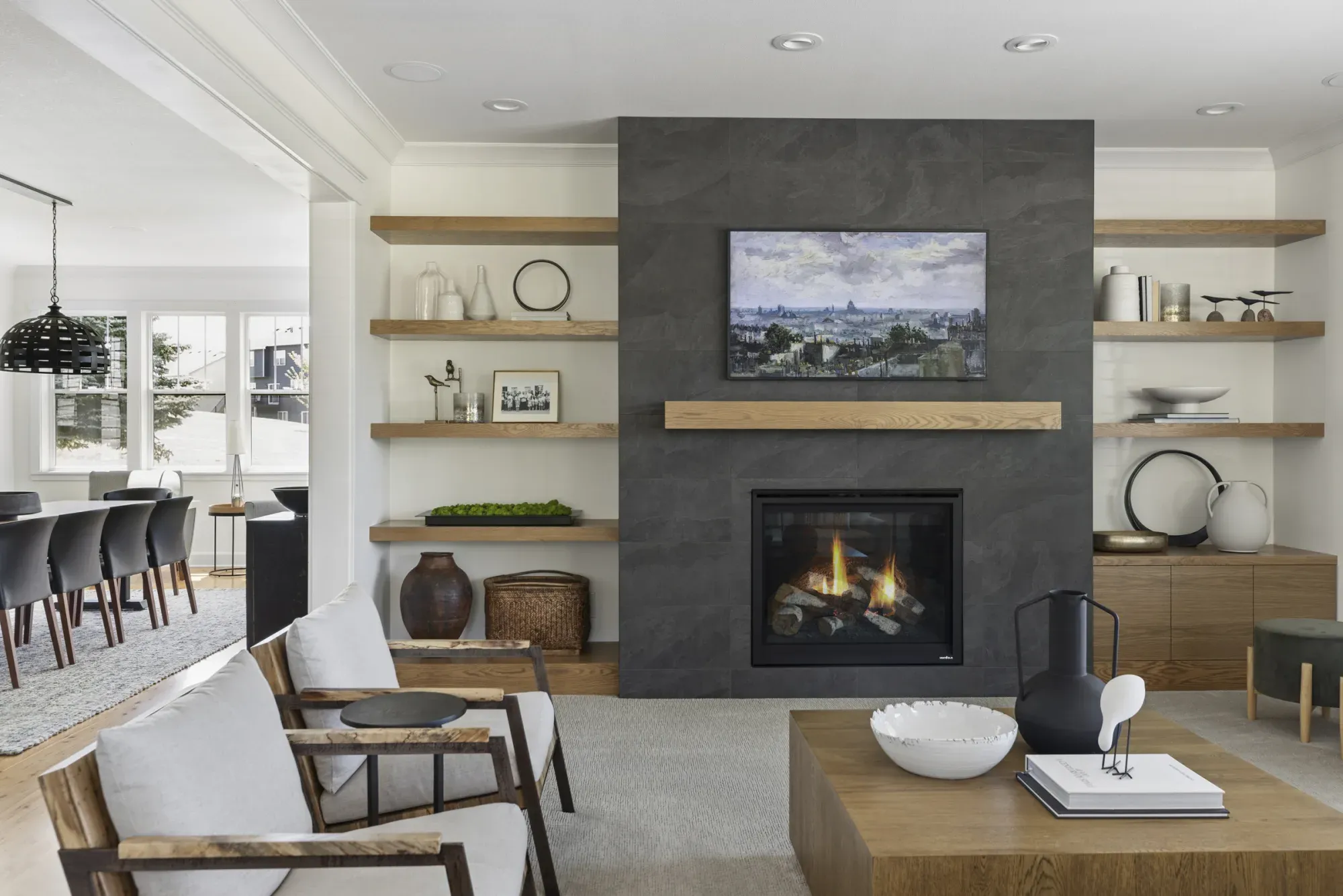 Remodeled living room in Lakeville, MN with gas fireplace, quarter-sawn white oak cabinetry, and black porcelain tile by Honey-Doers Remodeling