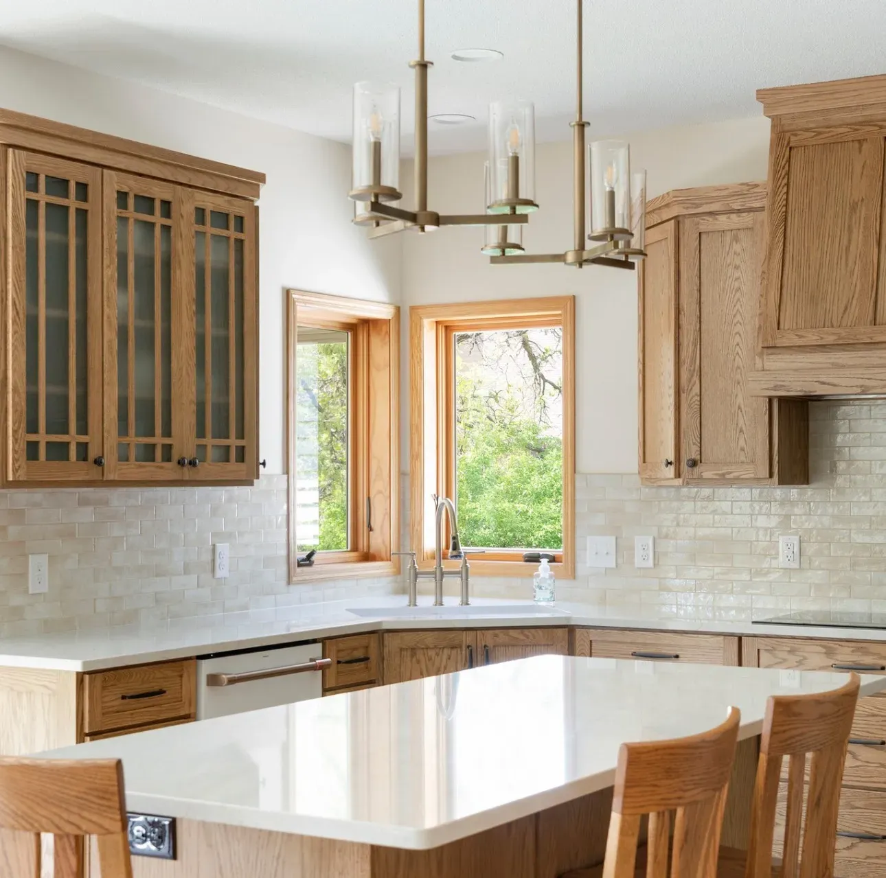 Remodeled Lakeville kitchen with custom red-oak shaker cabinetry, glass-front uppers, quartz island and brass pendant lighting by Honey-Doers Remodeling