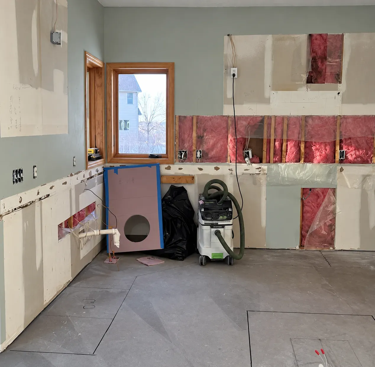 Demolition stage of a Lakeville kitchen remodel with a portable air scrubber and HEPA vacuum staged in the work area