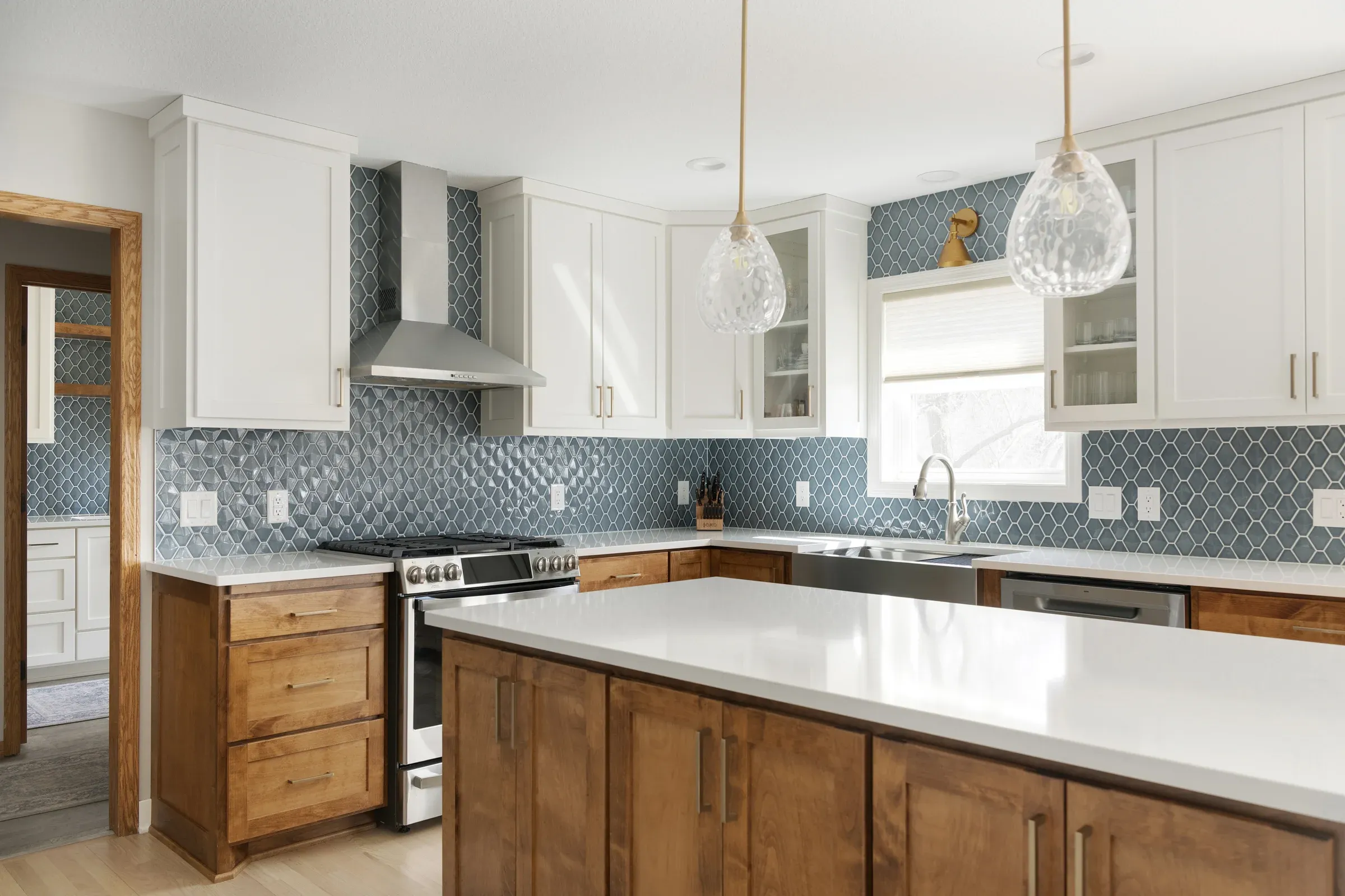 Elko New Market kitchen remodel – white upper cabinets, stained wood base cabinets, quartz countertops, and pendant lighting over island