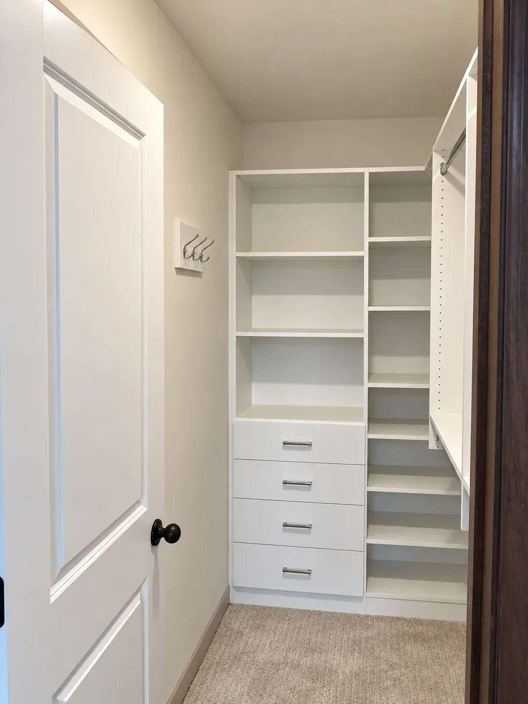 A small walk-in closet in Apple Valley with a drawer stack and shelf tower on the end wall and a hanging rod along the side wall