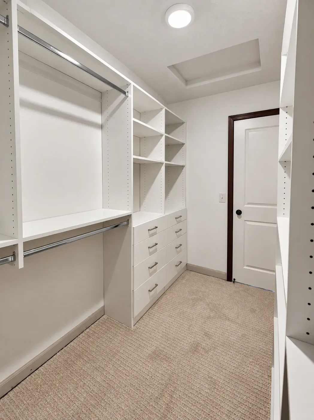 Wide view of an Apple Valley walk-in closet with double-hang rods, a drawer stack, and a flush ceiling light centered over the aisle
