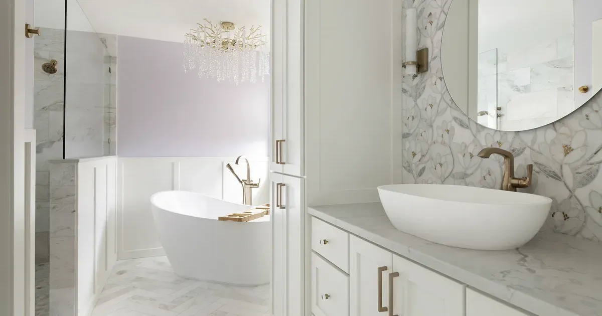 Primary bathroom remodel in Elko New Market, MN with a freestanding soaking tub, crystal chandelier, marble walk-in shower and vessel sink vanity by Honey-Doers